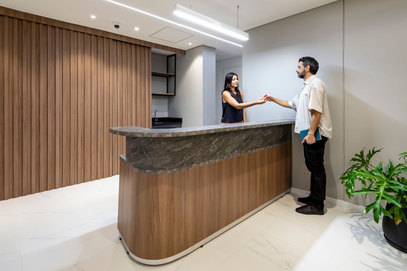 Aseguradora Yacyreta - Welcoming reception desk with wood slat textures and biophilic elements - Contract Workplaces.jpg